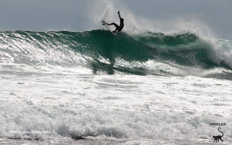 junger Tico-Surfer, der eine Welle fängt