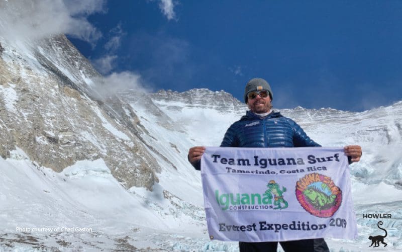 Surfear local Chad Gaston de Tamarindo Costa Rica, sostiene la bandera de su tienda en el monte Everest